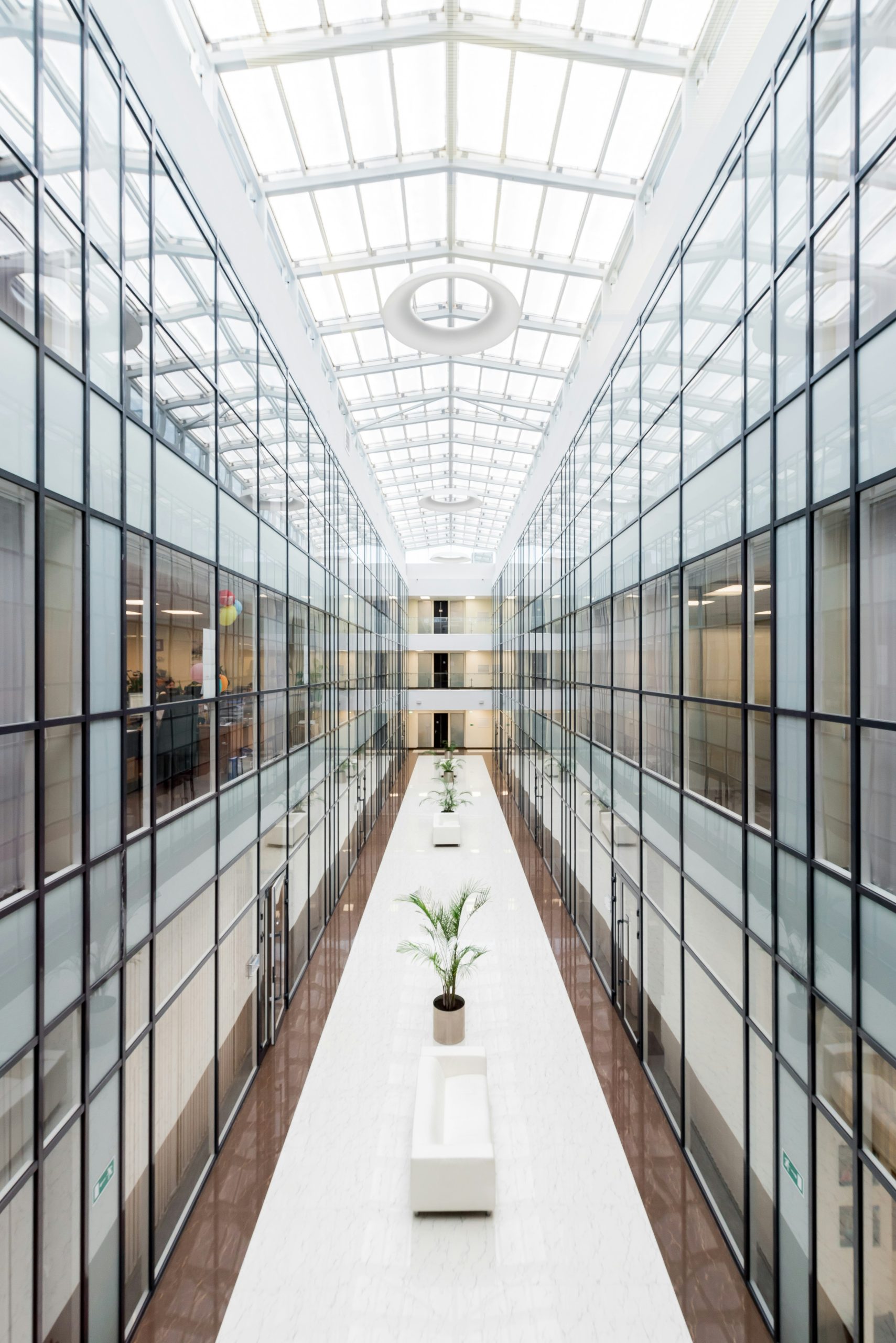 Glass-ceiling atrium hallway with symmetrical architecture